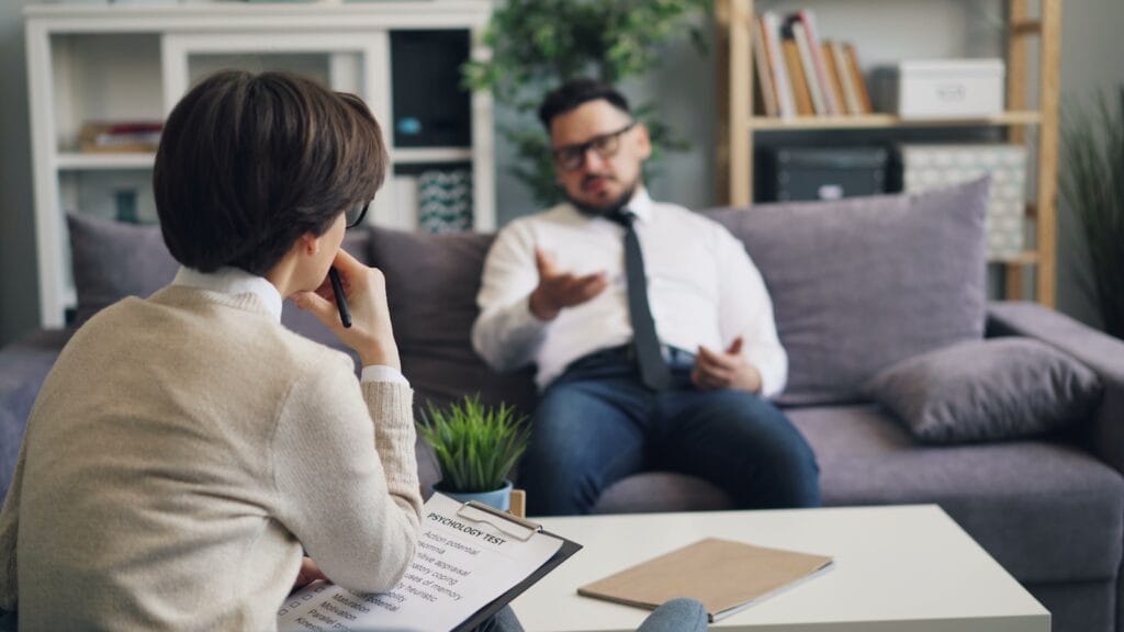 a man and a woman sitting on a couch in a living room